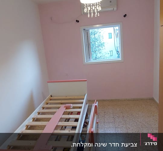 חדר עם קיר צבוע ורוד ומיטה לבנה